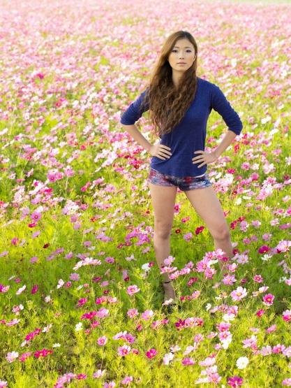 Okinawan girl in field of cosmos flowers.
