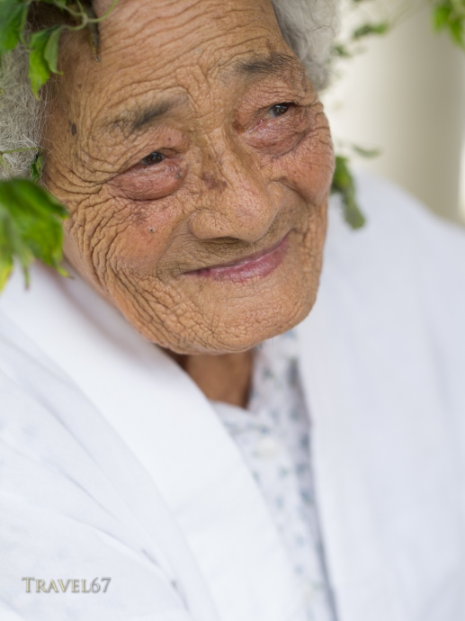 96 year old Kaneshi Fusae wearing wreath of ryukyu botanzuru at Unjami Festival on Kouri Island, Okinawa